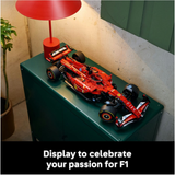Model Formula 1 car on a green surface with a red lamp in the background