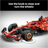 Red Formula 1 car model with steering wheel on a gray background